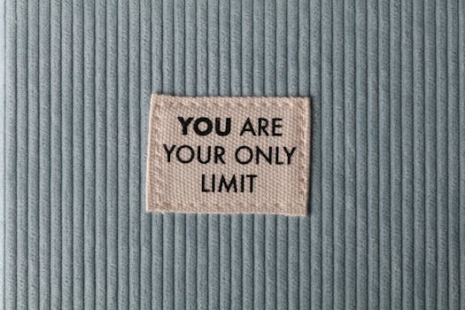 pexels-photo-3558662-3558662 Fabric patch on blue velvet with motivational text 'You Are Your Only Limit' in close-up view.